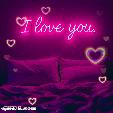 A Neon Sign That Says I Love You Is Above A Bed GIF