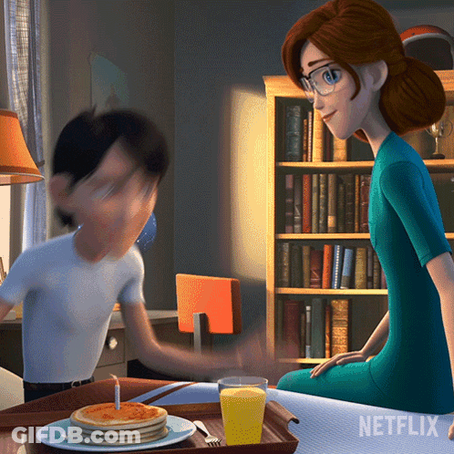A Netflix Ad Shows A Woman Sitting At A Table With A Tray Of Pancakes GIF
