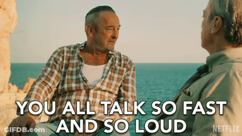 A Netflix Ad Shows Two Men Sitting On A Rock Near The Ocean And Says " You All Talk So Fast And So Loud " GIF
