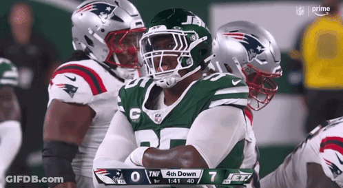 A New York Jets Football Player Stands With His Arms Crossed GIF