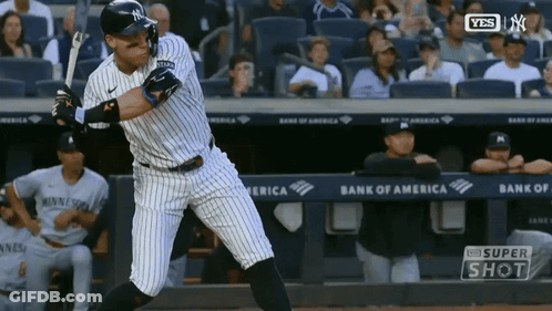 A New York Yankees Baseball Player Swings His Bat At A Ball GIF