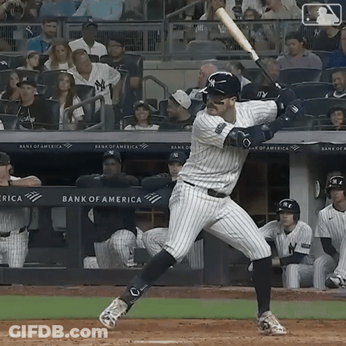 A New York Yankees Baseball Player Swings His Bat At The Ball GIF