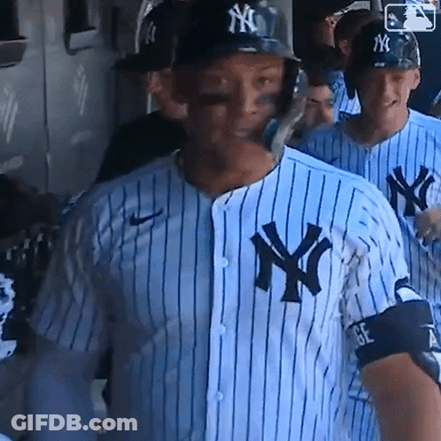 A New York Yankees Baseball Player Wearing A Helmet And A Striped Shirt GIF