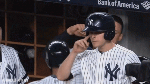 A New York Yankees Player Adjusts His Helmet In Front Of A Bank Of America Banner GIF