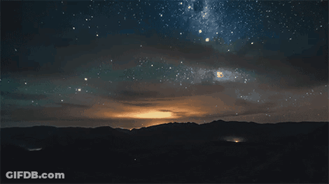 A Night Sky Filled With Lots Of Stars And Clouds GIF
