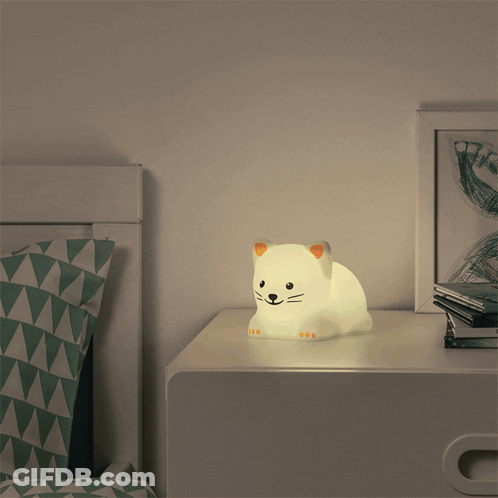 A Nightstand With A Cat Shaped Lamp On It GIF