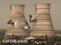 A Nuclear Power Plant Is Being Demolished With Smoke Coming Out Of It . GIF