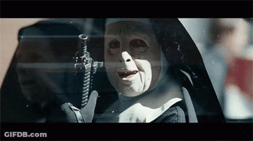 A Nun Is Holding A Gun In Front Of A Car Window GIF
