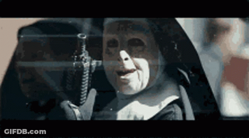 A Nun Is Holding A Gun In Her Hand In A Dark Room . GIF