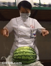 A Nurse In A White Uniform Is Cutting A Watermelon GIF