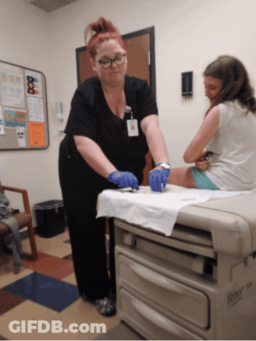 A Nurse Is Working On A Child 'S Leg In A Room That Has A Box That Says Rite GIF