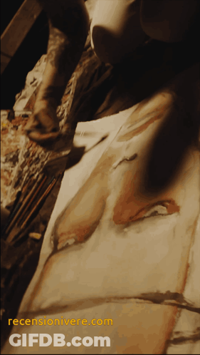 A Painting Is Being Painted On A Piece Of Paper With The Website Recensionivere.com In Yellow GIF