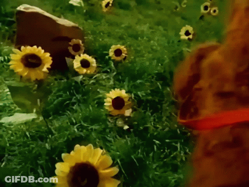 A Painting Of A Field Of Sunflowers With A Rock In The Background GIF
