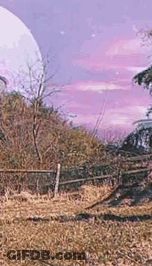 A Painting Of A Field With A Fence And Trees In The Background . GIF