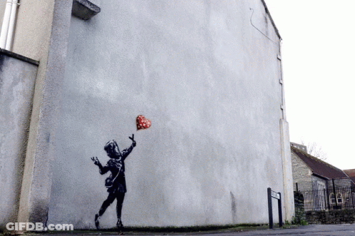 A Painting Of A Girl Holding A Heart Shaped Balloon On The Side Of A Building GIF