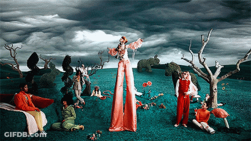 A Painting Of A Group Of People In A Field With A Woman On Stilts GIF