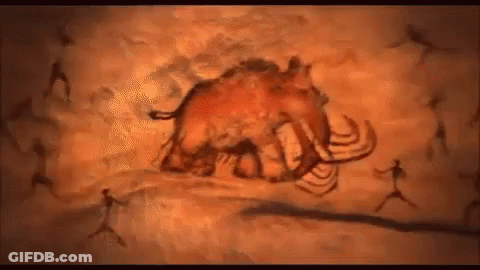 A Painting Of A Mammoth In A Cave With People Walking Around It . GIF