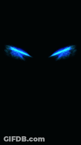 A Pair Of Blue Eyes Glowing In The Dark On A Black Background GIF