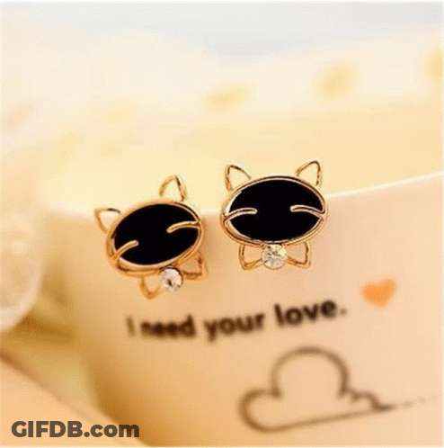 A Pair Of Cat Shaped Earrings With Black And Clear Stones GIF