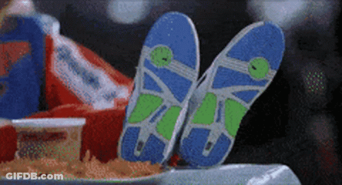 A Pair Of Flip Flops Are Laying On A Table Next To A Bag Of French Fries GIF