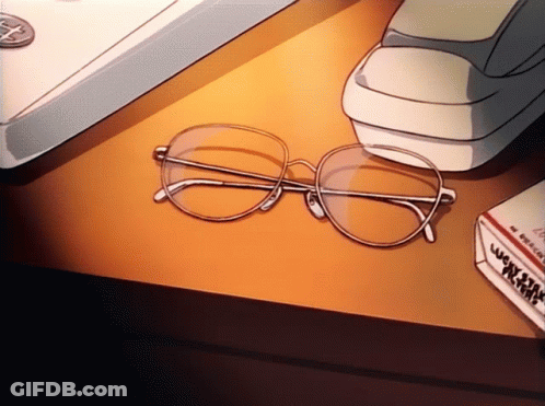 A Pair Of Glasses Sits On A Table Next To A Box Of Cigarettes GIF