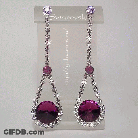 A Pair Of Purple And White Swarovski Earrings On Display GIF
