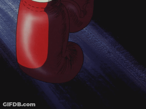 A Pair Of Red Boxing Gloves Are Hanging From A Wall GIF