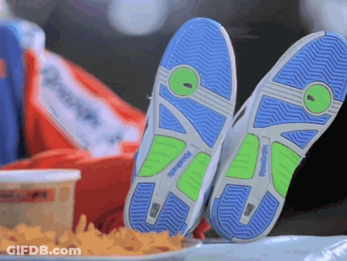 A Pair Of Reebok Shoes Are Laying On A Table Next To A Plate Of French Fries GIF