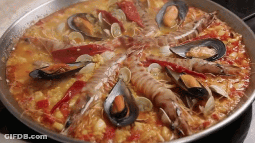 A Pan Filled With A Variety Of Seafood Including Shrimp Mussels And Peppers GIF