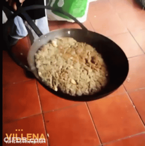 A Pan Filled With Food Is On A Tiled Floor And Says Villena On The Bottom Right GIF