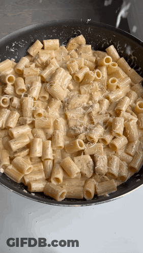 A Pan Filled With Macaroni And Cheese Being Cooked GIF