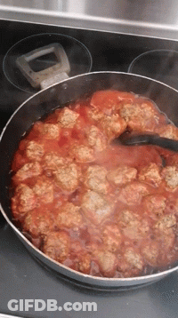 A Pan Filled With Meatballs And Sauce Is Cooking On A Stove GIF