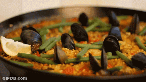 A Pan Filled With Rice Mussels Green Beans And Lemon Slices GIF