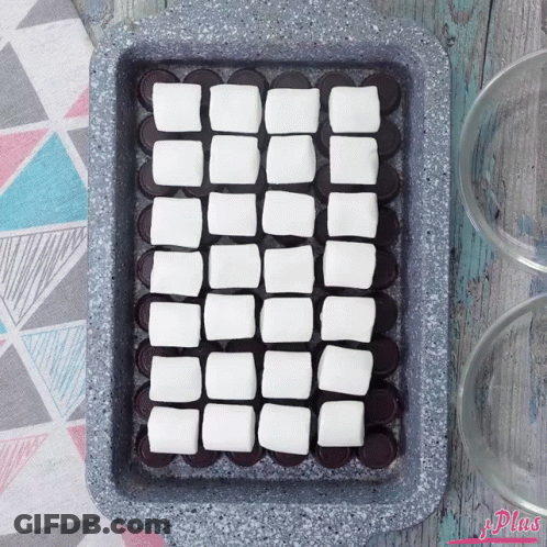 A Pan Filled With Squares Of Marshmallows On Top Of Chocolate Covered Oreos GIF