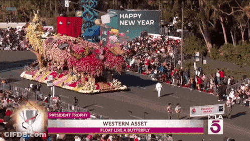 A Parade With A Float That Says President Trophy On It GIF