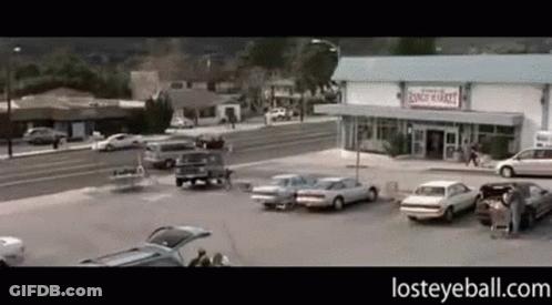 A Parking Lot With Cars Parked In Front Of A Ranch Market GIF