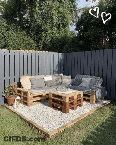 A Patio With A Couch And A Table Made Out Of Pallets GIF