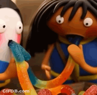A Penguin And A Girl Are Eating Gummy Worms Together . GIF
