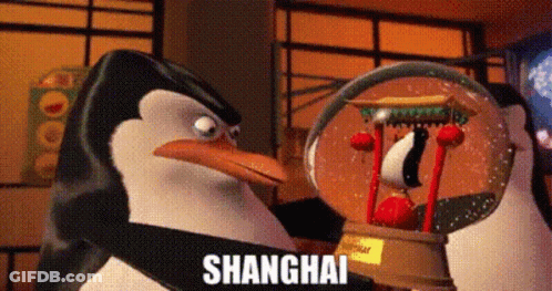 A Penguin Is Holding A Snow Globe With The Word Shanghai Written On It . GIF