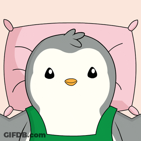 A Penguin Is Laying On A Pink Pillow With A Green Shirt On GIF