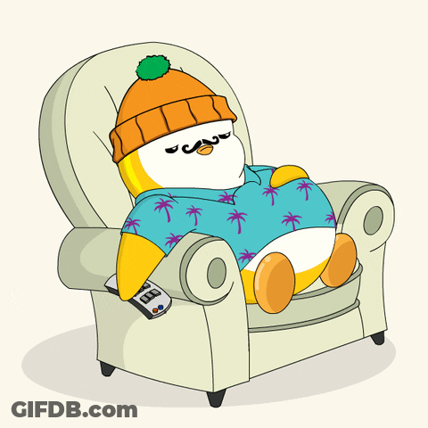 A Penguin Is Sitting In A Chair With A Remote Control GIF