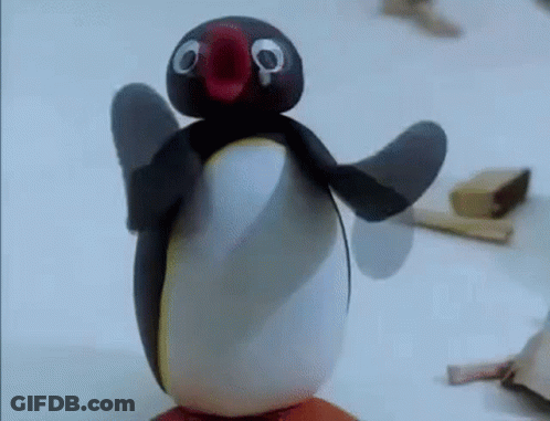 A Penguin Made Out Of Clay Is Standing On Top Of A Piece Of Wood . GIF