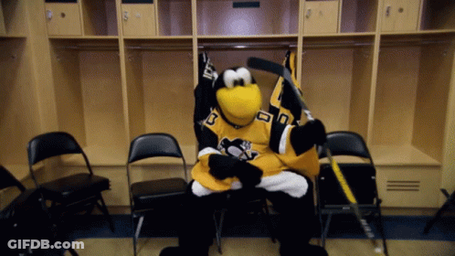 A Penguin Mascot In A Pittsburgh Penguins Jersey Sits In A Locker Room Holding A Hockey Stick GIF