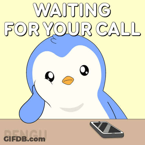 A Penguin Sits At A Table Waiting For A Call With A Cell Phone GIF