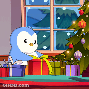 A Penguin Sits In Front Of A Christmas Tree With Presents GIF