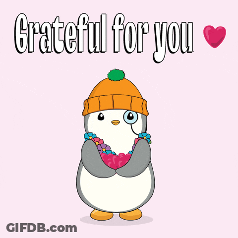 A Penguin Wearing A Beanie And Flowers Around Its Neck Is Grateful For You GIF