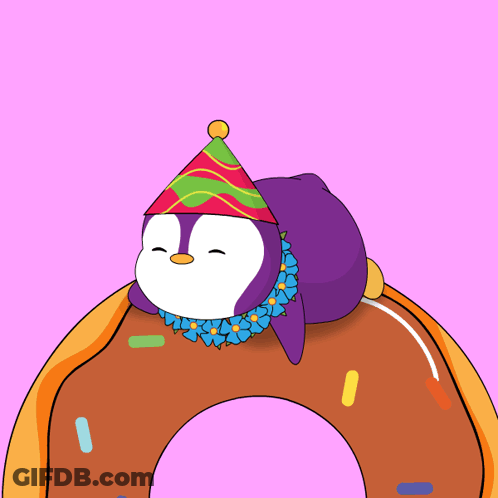 A Penguin Wearing A Party Hat Is Laying On Top Of A Doughnut GIF