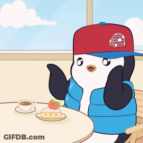 A Penguin Wearing An Igloo Hat Sits At A Table GIF