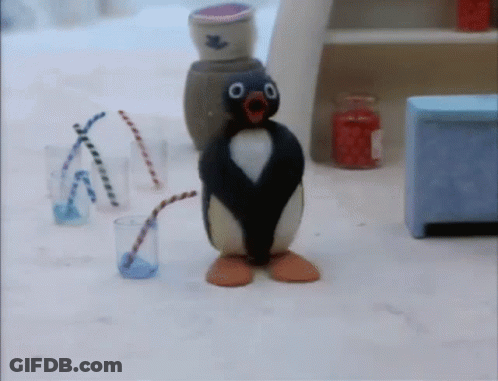 A Penguin With A Straw In Its Mouth Is Standing Next To A Glass Of Water GIF