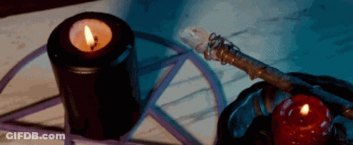 A Pentagram Is Surrounded By Candles And A Wand GIF